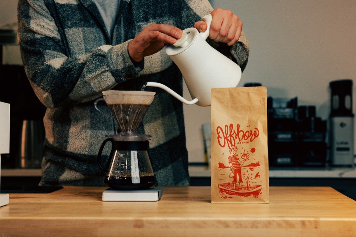 Pour-over coffee being brewed beside a bag of Offshore Coffee